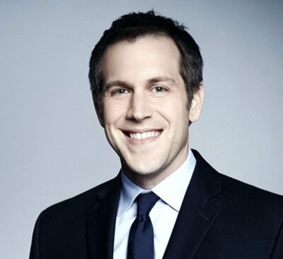 Jordy Jones pose avec son ordinateur portable et son fils sur les genoux.